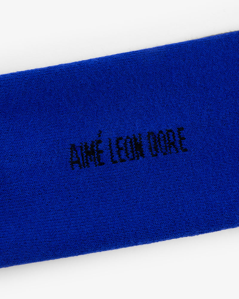Close-up of blue fabric with black AIMÉ LEON DORE embroidery from the Crew Sock 3-Pack.