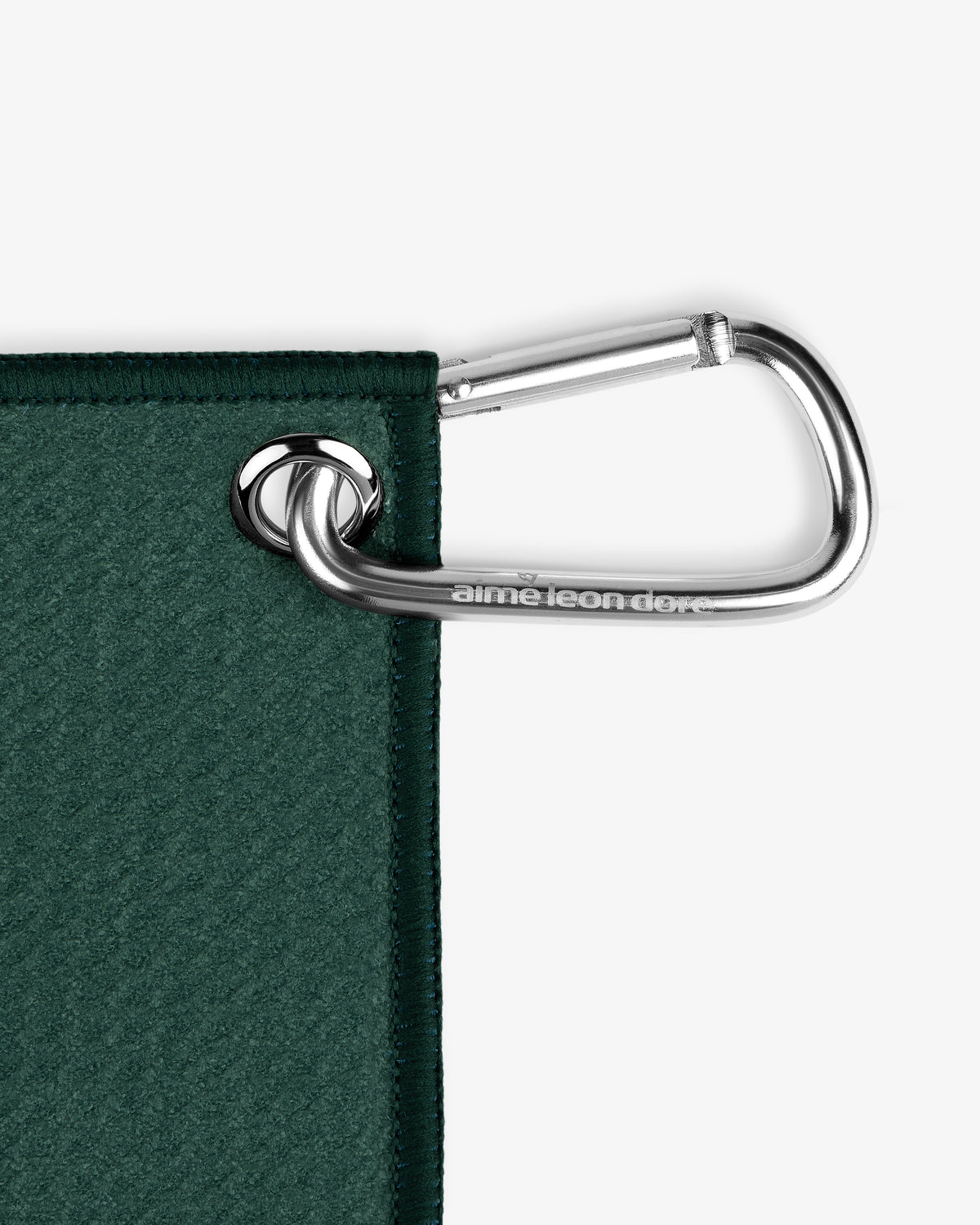 A silver carabiner attaches the ALD Golf Caddy Towel to a metal grommet in its dark green corner.