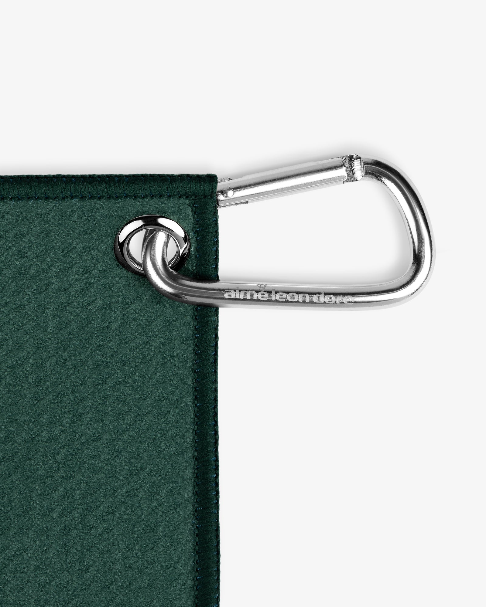 A silver carabiner attaches the ALD Golf Caddy Towel to a metal grommet in its dark green corner.
