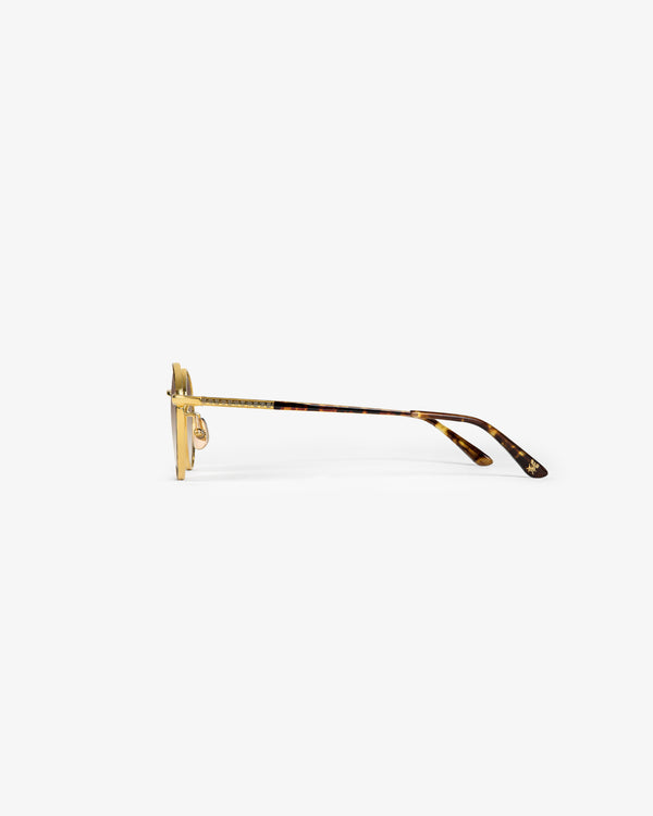 Side view of Giórgios Sunglasses in gold and tortoiseshell with clear nose pads on a plain white background.