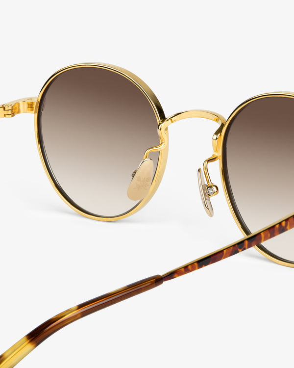 Giórgios Sunglasses: round gold frame, brown gradient lenses, tortoiseshell arms on white background.