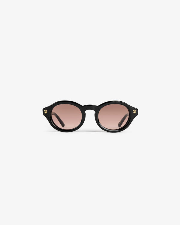 Onásis Sunglasses: black, round frames with pink tinted lenses, shown front-facing on a plain white background.