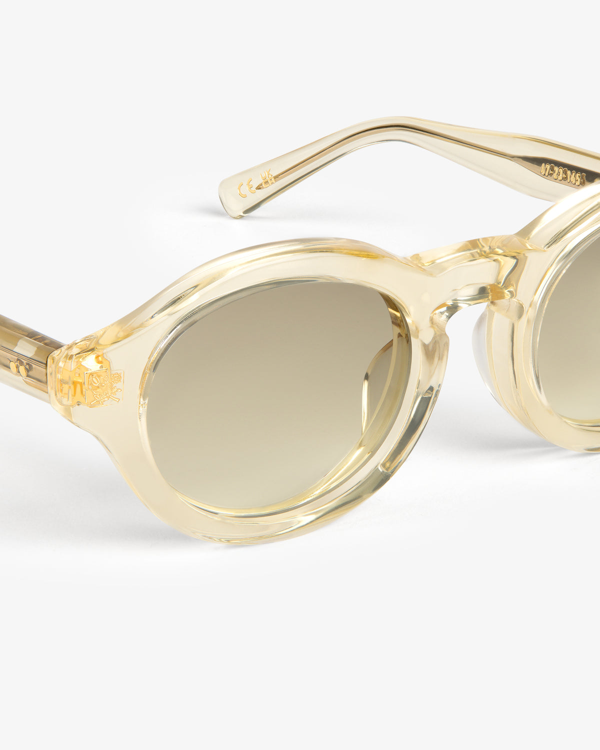 Onásis Sunglasses: Beige, round, translucent frames with gradient lenses on a white background.