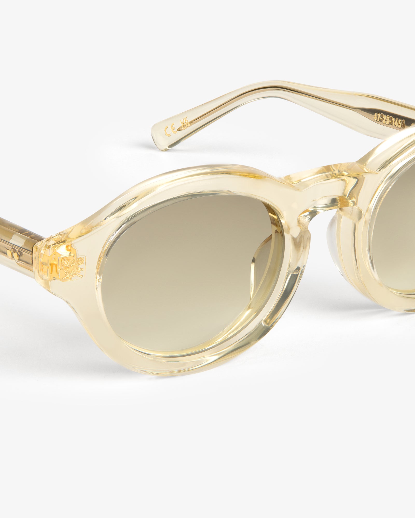 Onásis Sunglasses: Beige, round, translucent frames with gradient lenses on a white background.