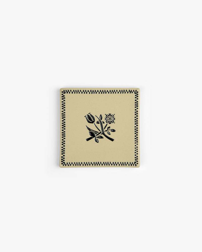 Crest Coaster (Set of 4): Square cream-colored coasters with black rose and checkered border, on white background.