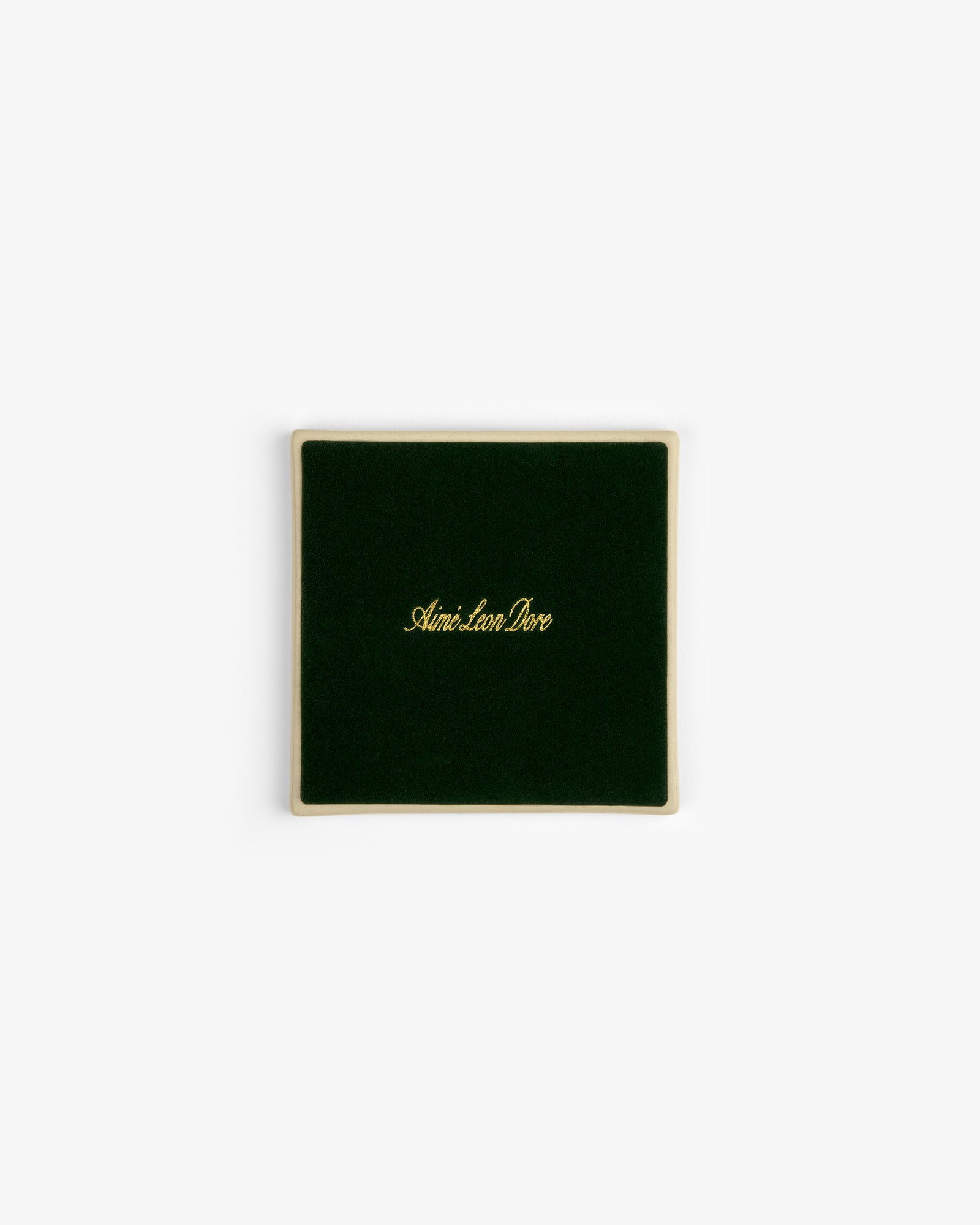 A set of four square green velvet Crest Coasters with gold Aimé Leon Dore text, shown on a white background.