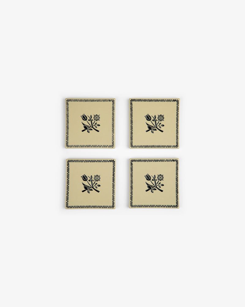 Crest Coaster (Set of 4): Beige coasters with black floral and zigzag designs, arranged in a two-by-two grid.