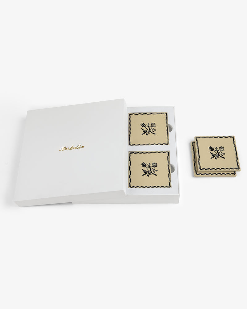 A white box labeled "Crest Coaster (Set of 4)" holds beige floral coasters; two are displayed beside the box.