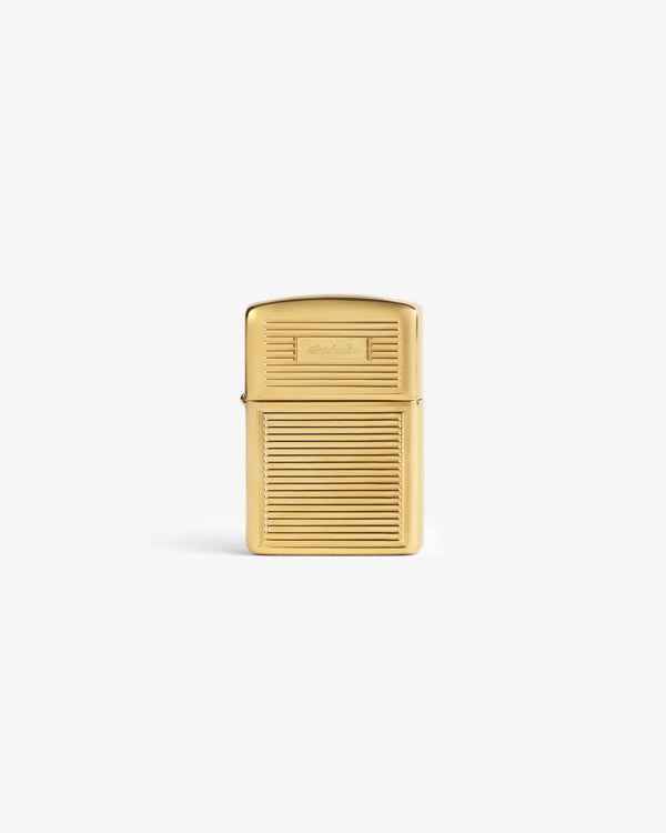 A Brass Zippo Lighter with a ridged design stands upright against a plain white background.