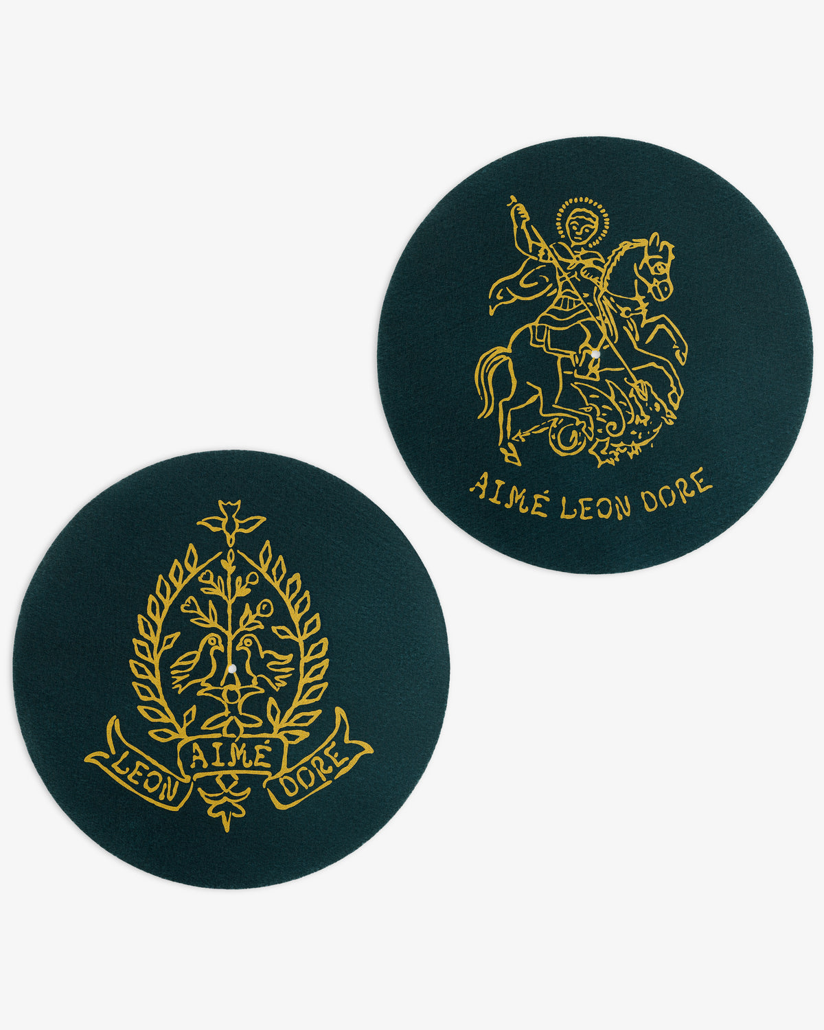 Two dark green Graphic Slip Mats featuring intricate gold Aimé Leon Dore logos in the center.
