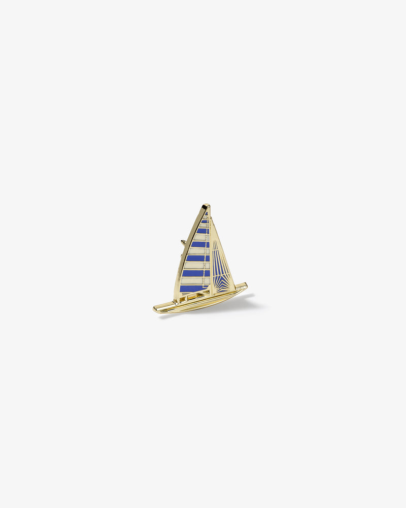 Graphic Pin featuring a gold and blue enamel sailboat with striped sails on a plain white background.