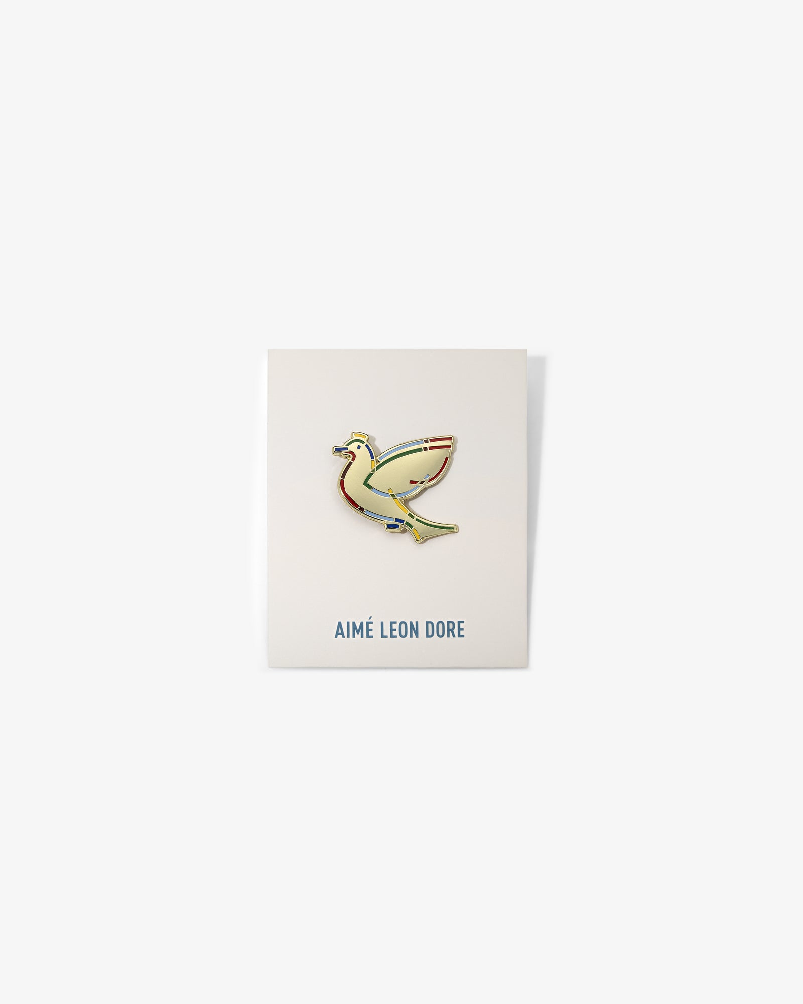 Graphic Pin featuring a yellow bird on a white card with AIMÉ LEON DORE in blue at the bottom.