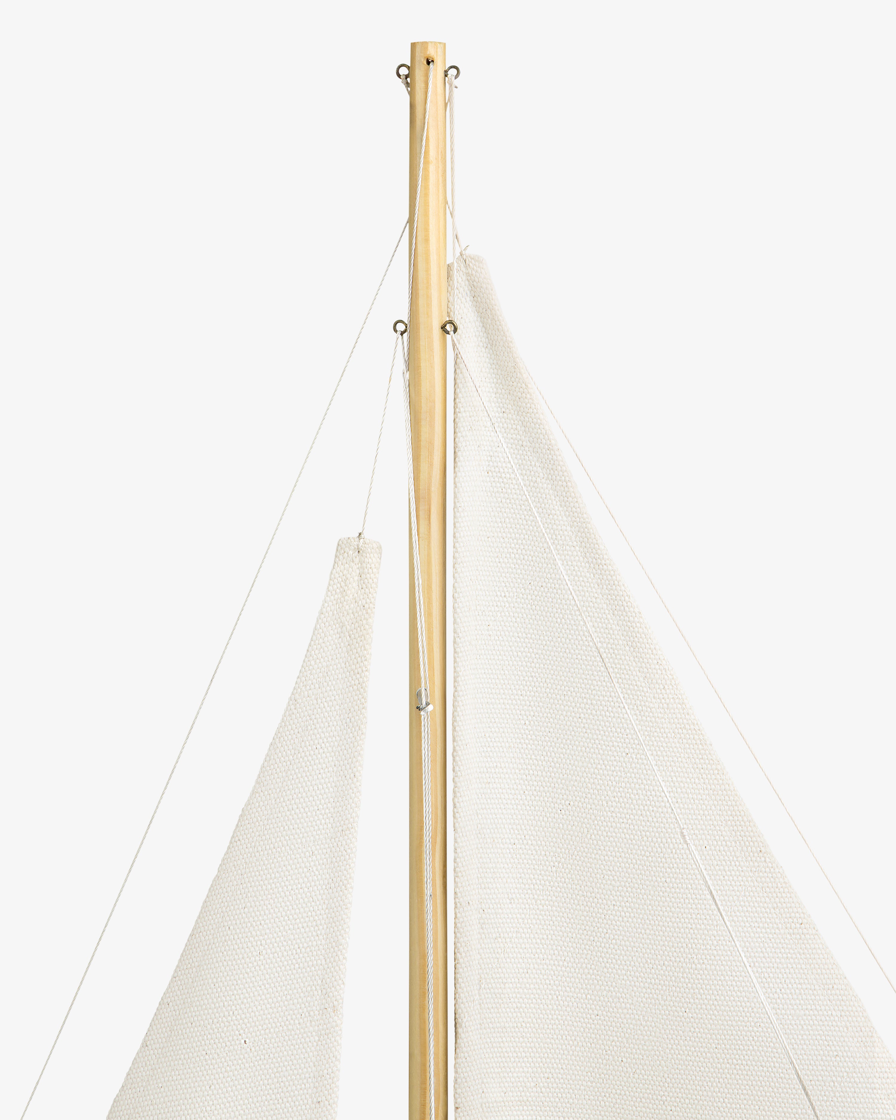 Close-up of the Walnut Model Sailboat's mast with white sails and thin ropes against a white background.