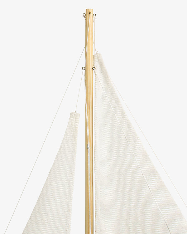 Close-up of the Walnut Model Sailboat's mast with white sails and thin ropes against a white background.