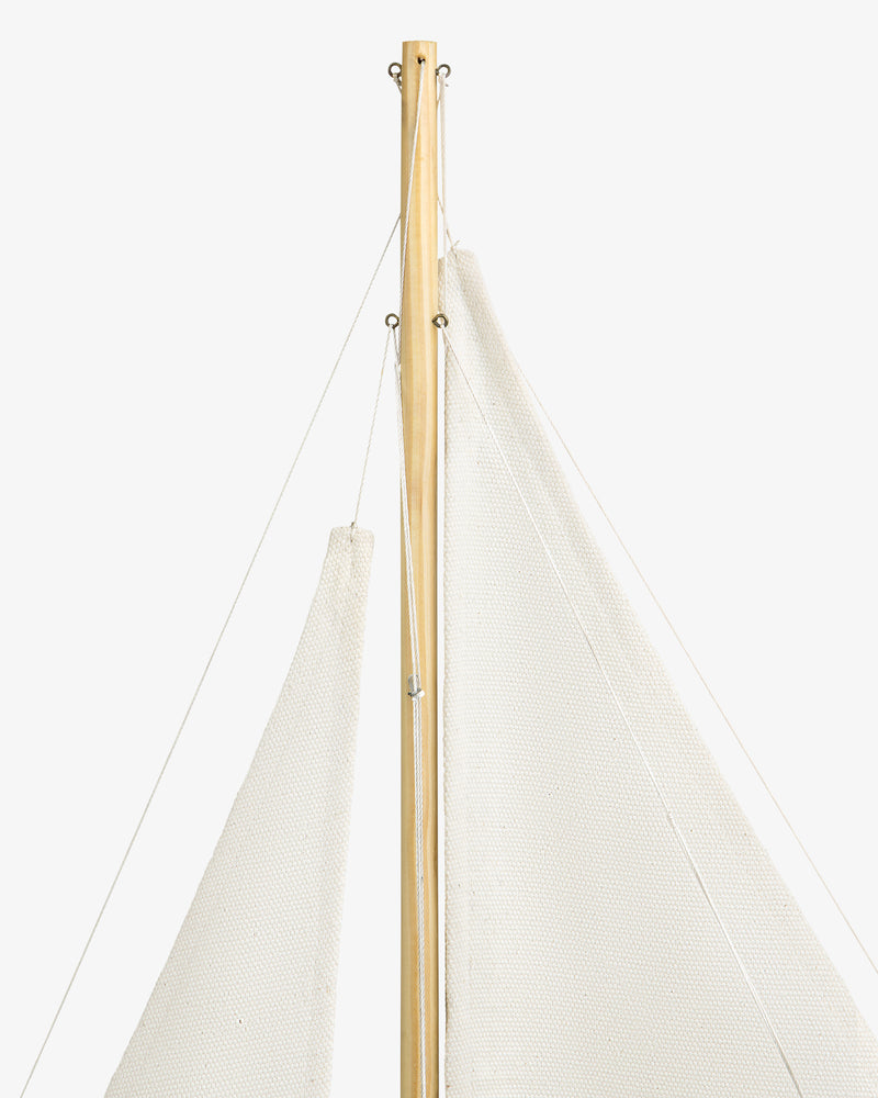 Close-up of the Walnut Model Sailboat's mast with white sails and thin ropes against a white background.