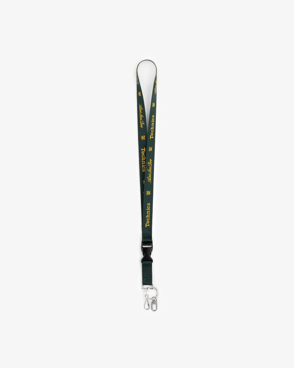 ALD / Technics dark green lanyard with yellow text, metal clasp, and key ring on white background.