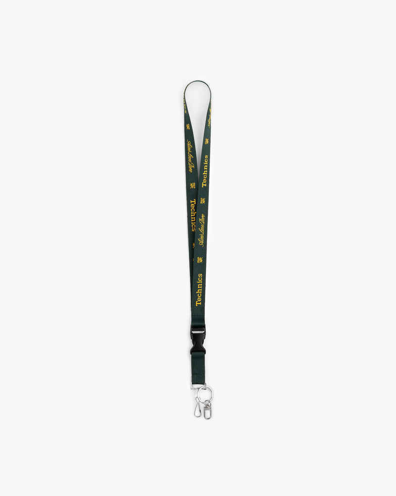ALD / Technics dark green lanyard with yellow text, metal clasp, and key ring on white background.