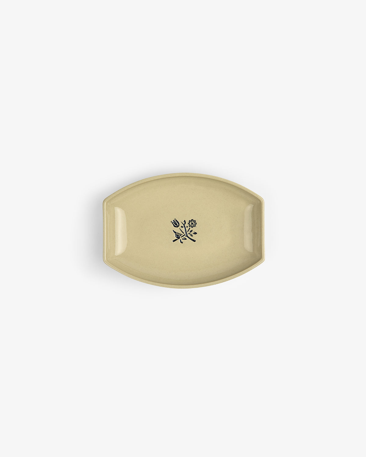 Crest Catchall: Oval beige dish with a small black floral design in the center, shown on a white background.