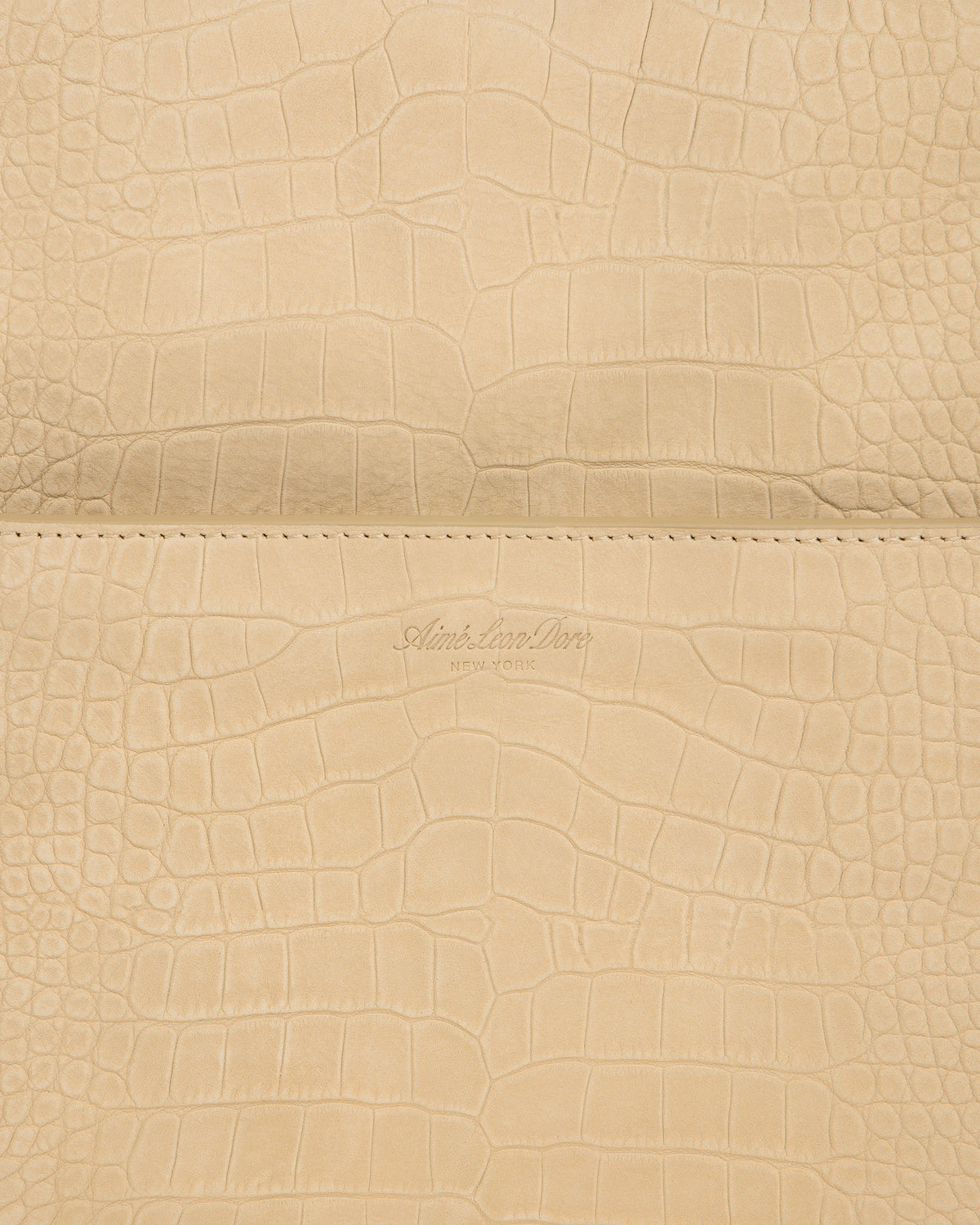 Beige croc-embossed nubuck duffle with Aime Leon Dore New York logo debossed at the center.