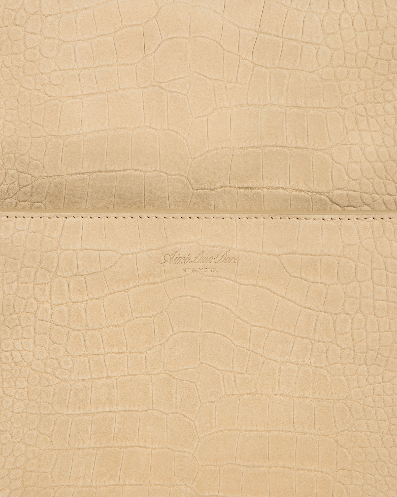 Beige croc-embossed nubuck duffle with Aime Leon Dore New York logo debossed at the center.