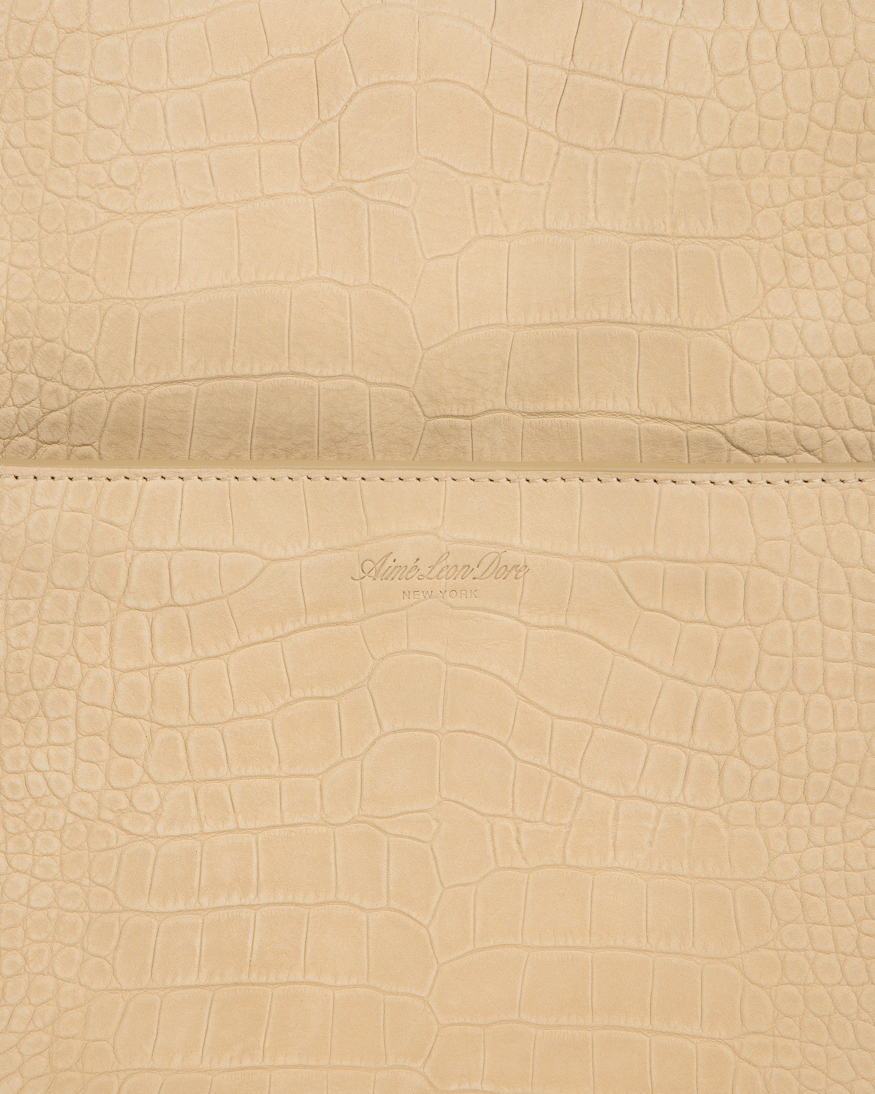 Beige croc-embossed nubuck duffle with Aime Leon Dore New York logo debossed at the center.