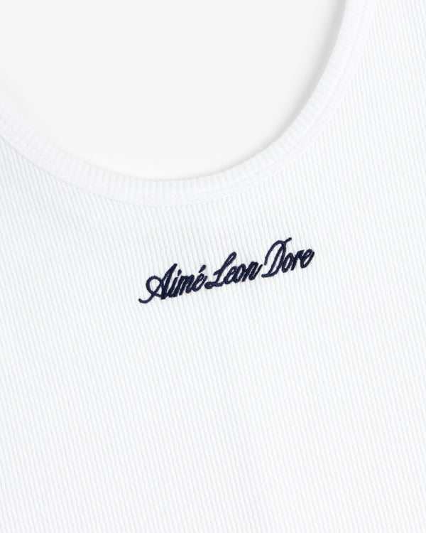 Close-up of a white ribbed Embroidered Logo Tank Dress with navy Aimé Leon Dore cursive near the neckline.