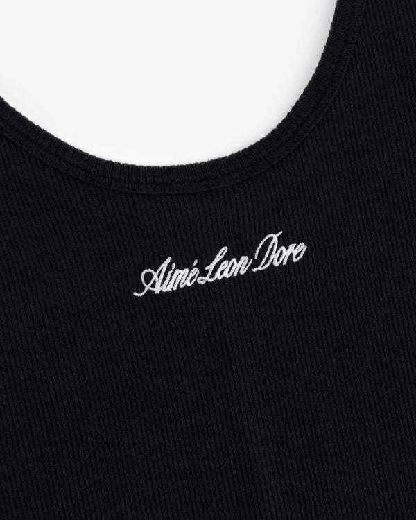 Close-up of black ribbed fabric on the Embroidered Logo Tank Dress with Aimé Leon Dore in white cursive.