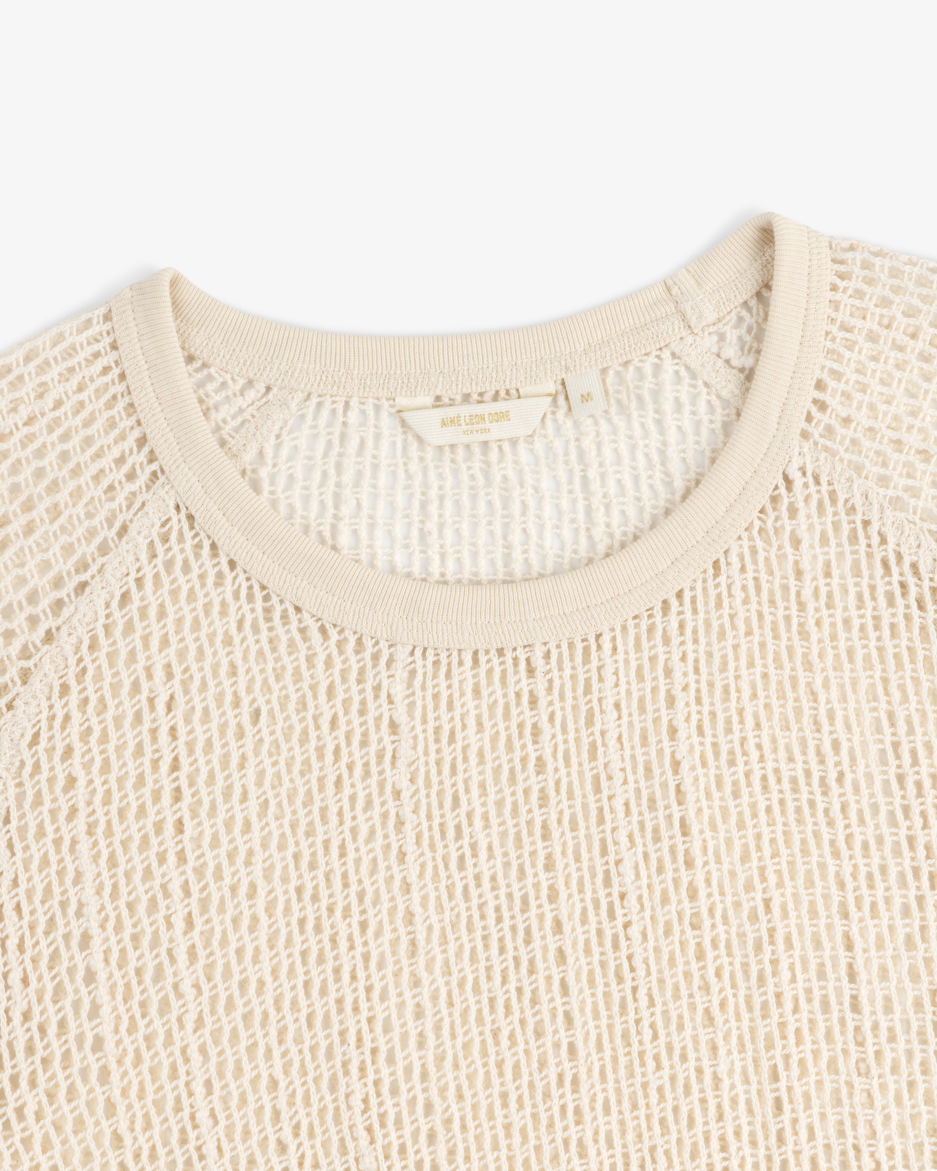 A close-up of an Open Mesh Mini Dress in cream with a waffle-knit texture and a visible collar label.