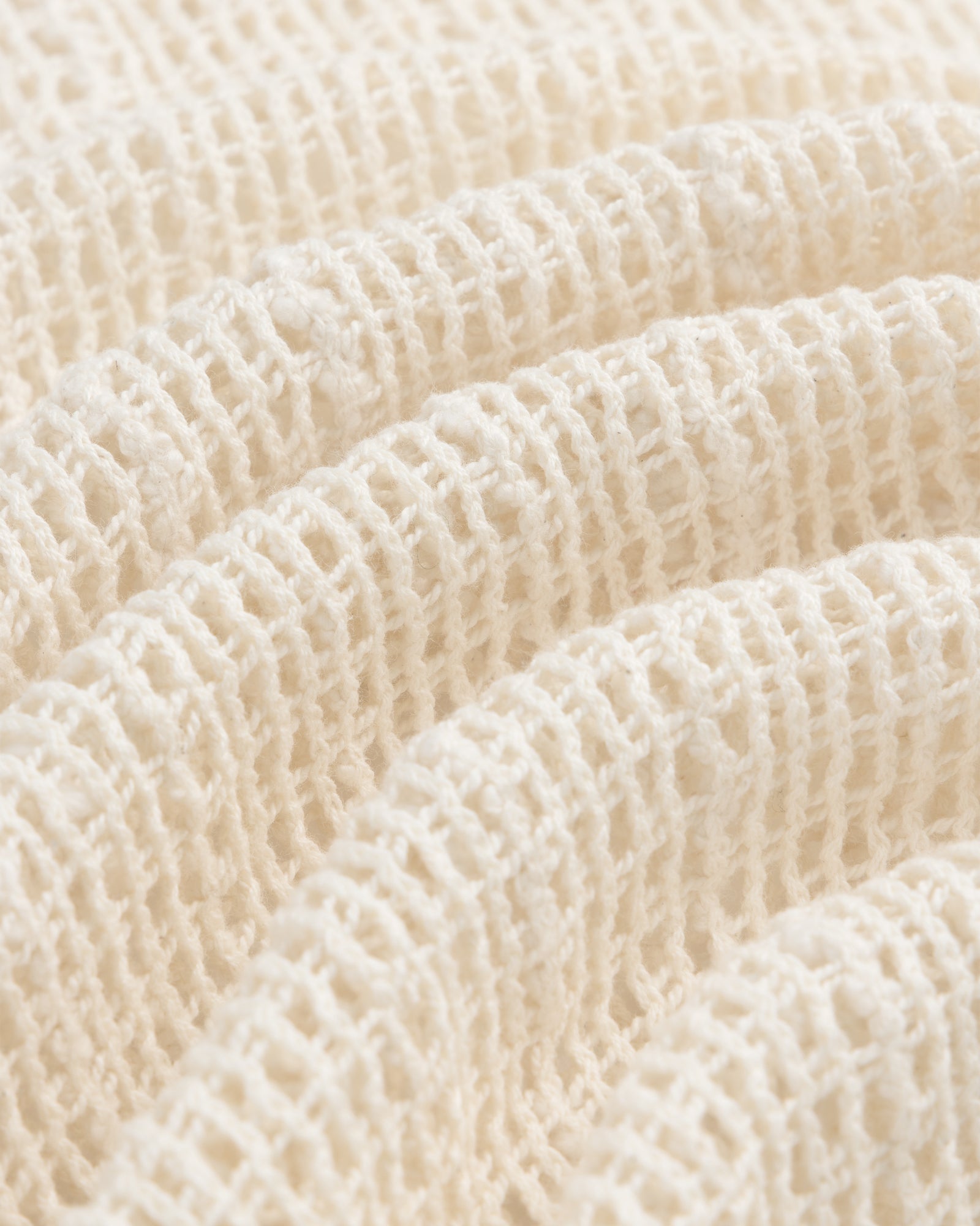 Open Mesh Mini Dress in cream-colored textured waffle fabric, softly folded under bright lighting.