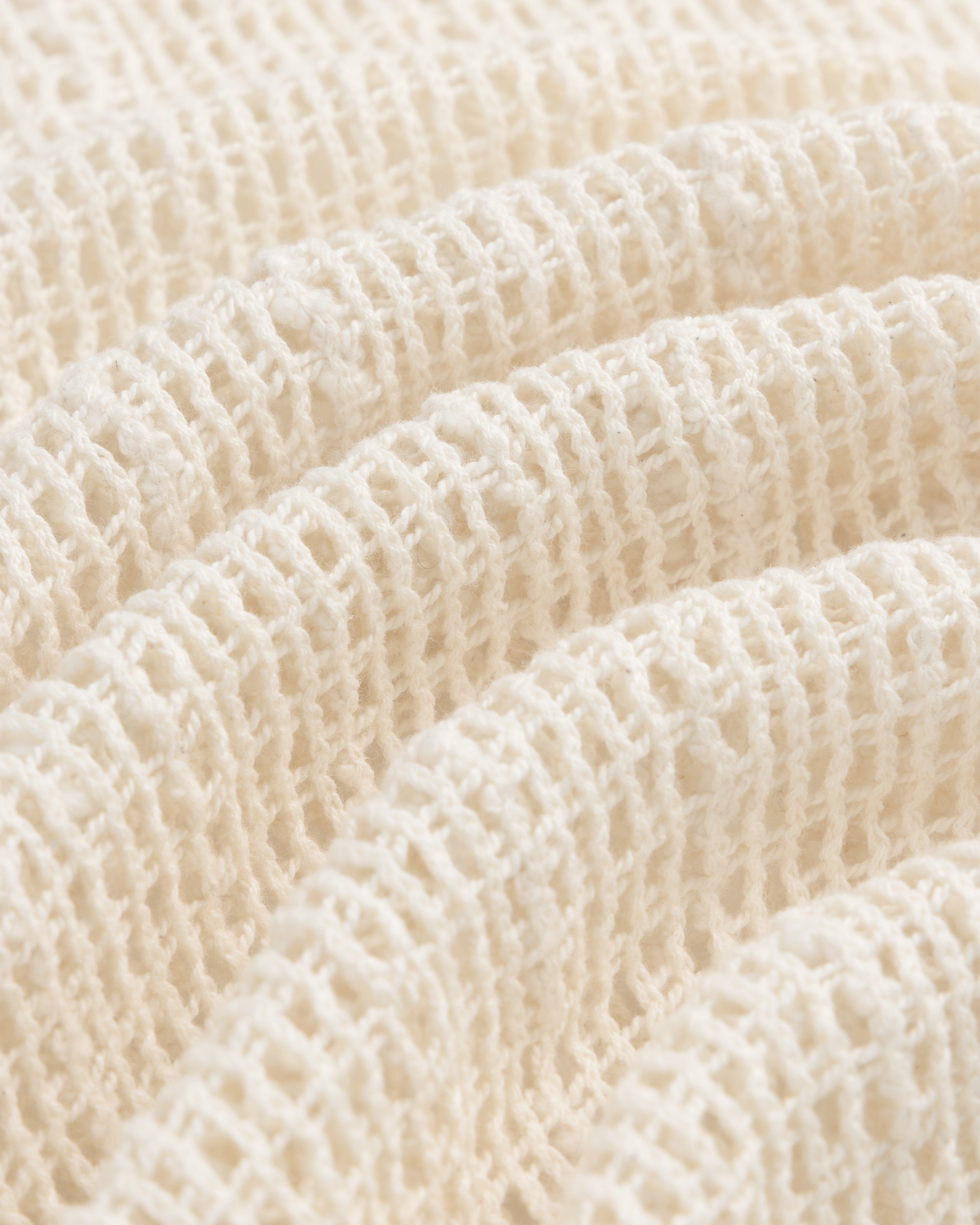 Open Mesh Mini Dress in cream-colored textured waffle fabric, softly folded under bright lighting.