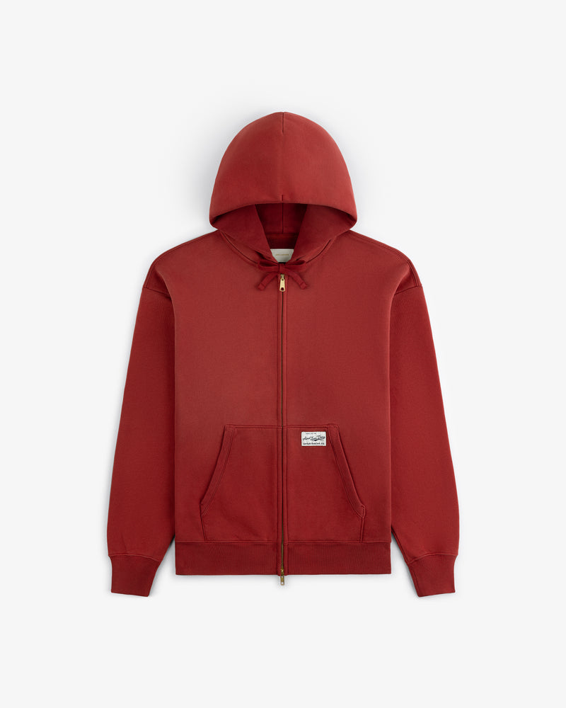 Sun Faded Full-Zip Hoodie in red with front pockets, drawstring hood, and small white label on left pocket.