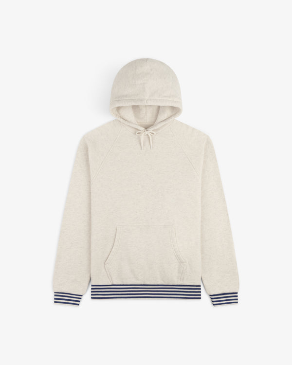Dock Hoodie in light beige, featuring a front pocket and navy striped ribbed cuffs and waistband, laid flat on white.