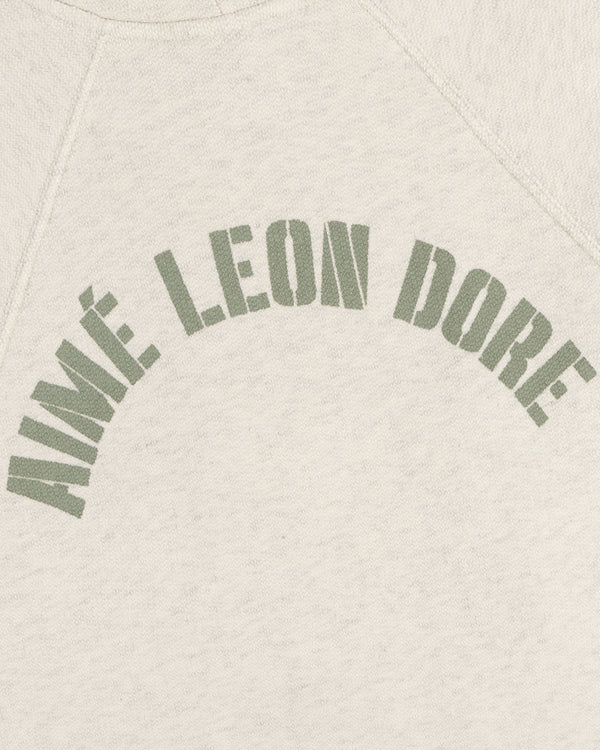 Cream Dock Hoodie with AIMÉ LEON DORE in bold, olive green, arched block letters across the chest.