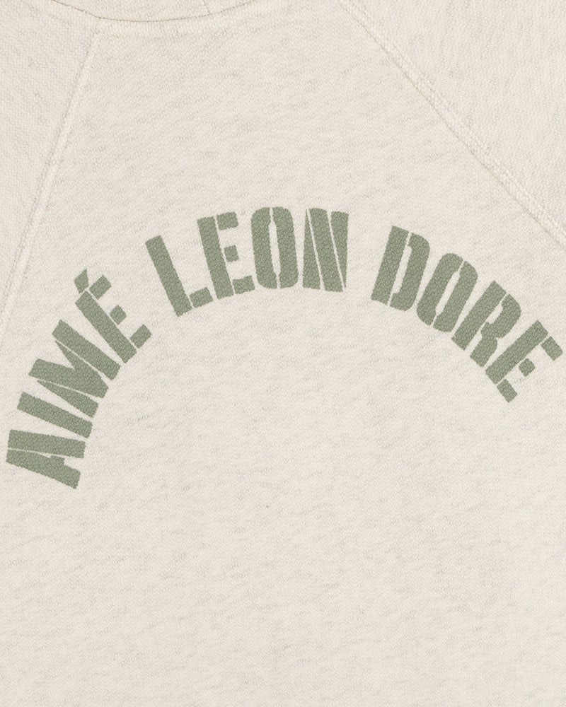 Cream Dock Hoodie with AIMÉ LEON DORE in bold, olive green, arched block letters across the chest.