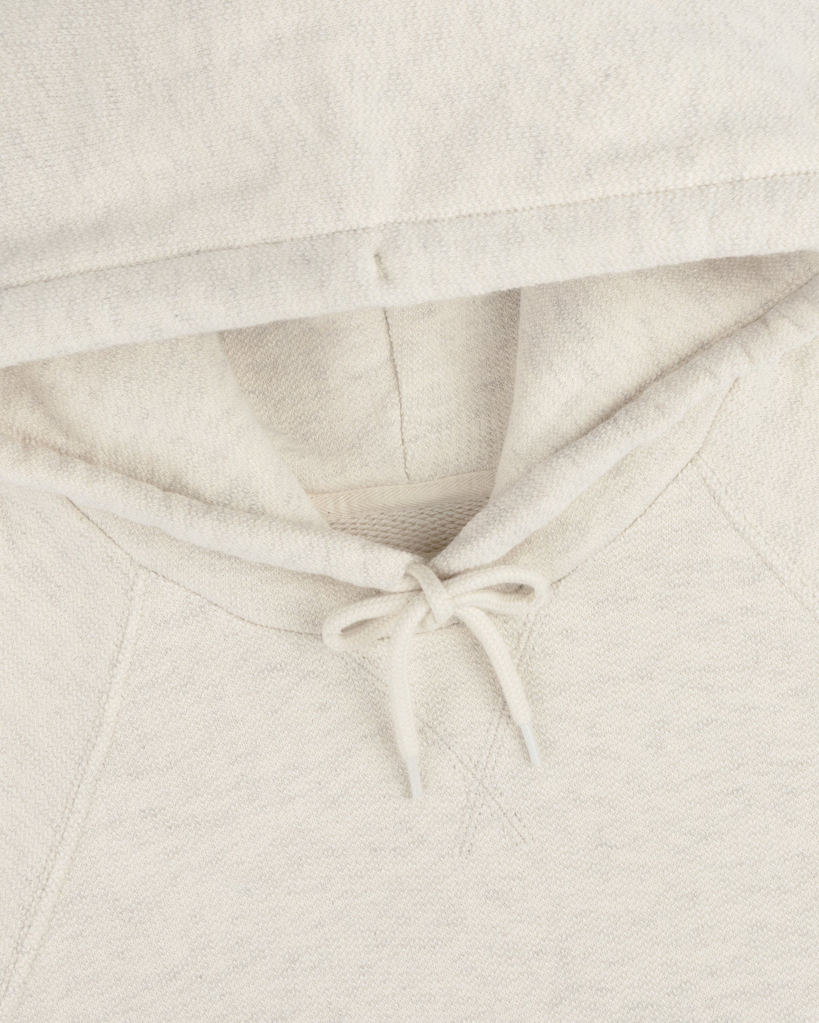 Close-up of the Dock Hoodie in light beige, featuring the hood, drawstring, and part of the neckline.