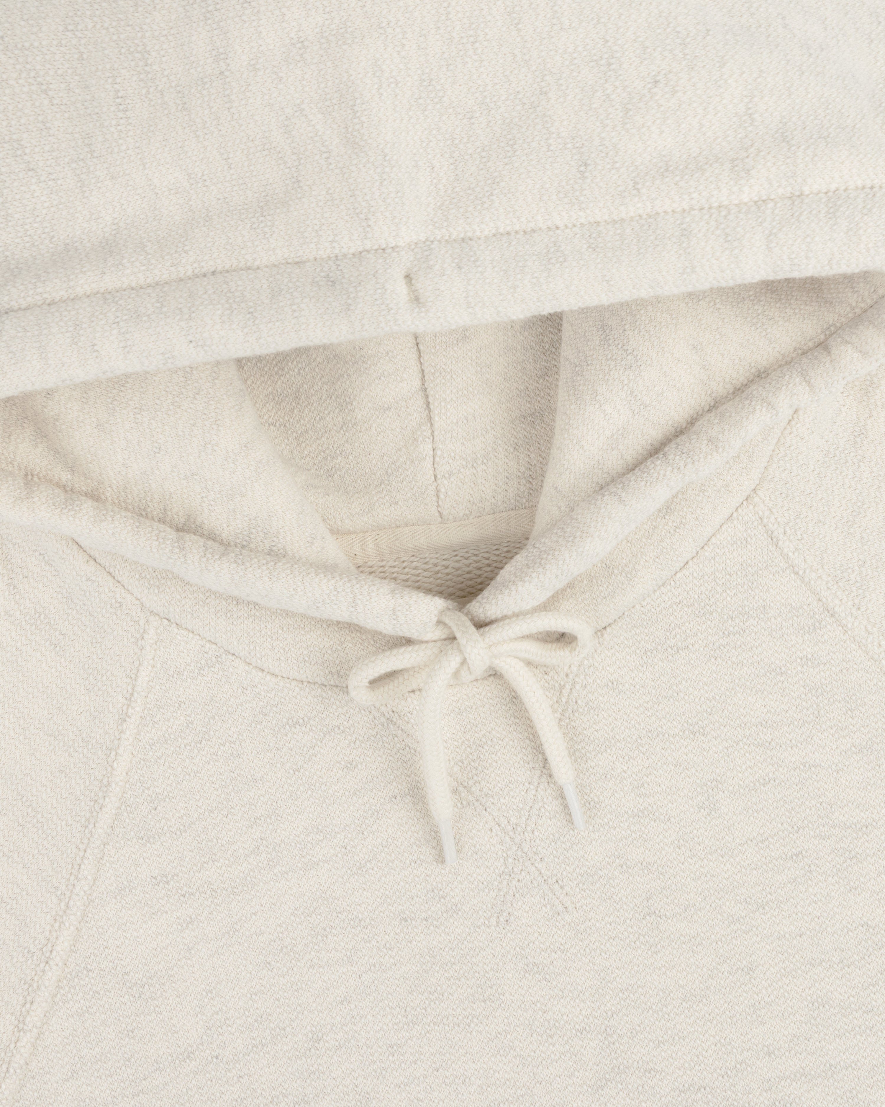 Close-up of the Dock Hoodie in light beige, featuring the hood, drawstring, and part of the neckline.