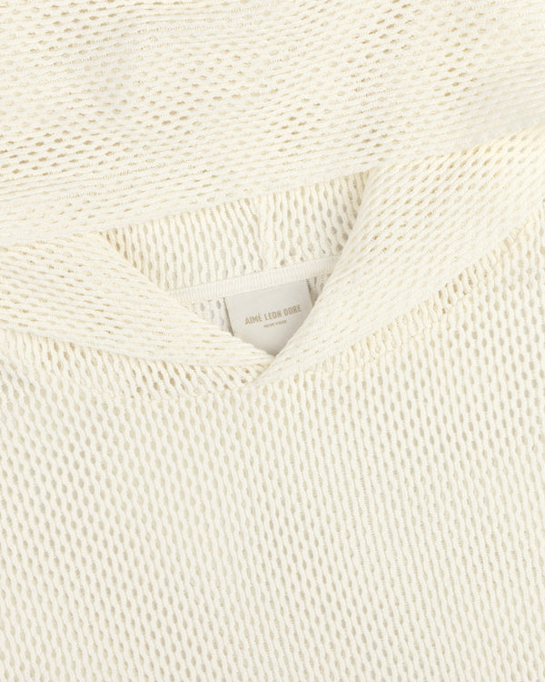 Close-up of a cream-colored open mesh hoodie with a textured knit and a visible AIMÉ LEON DORE label.