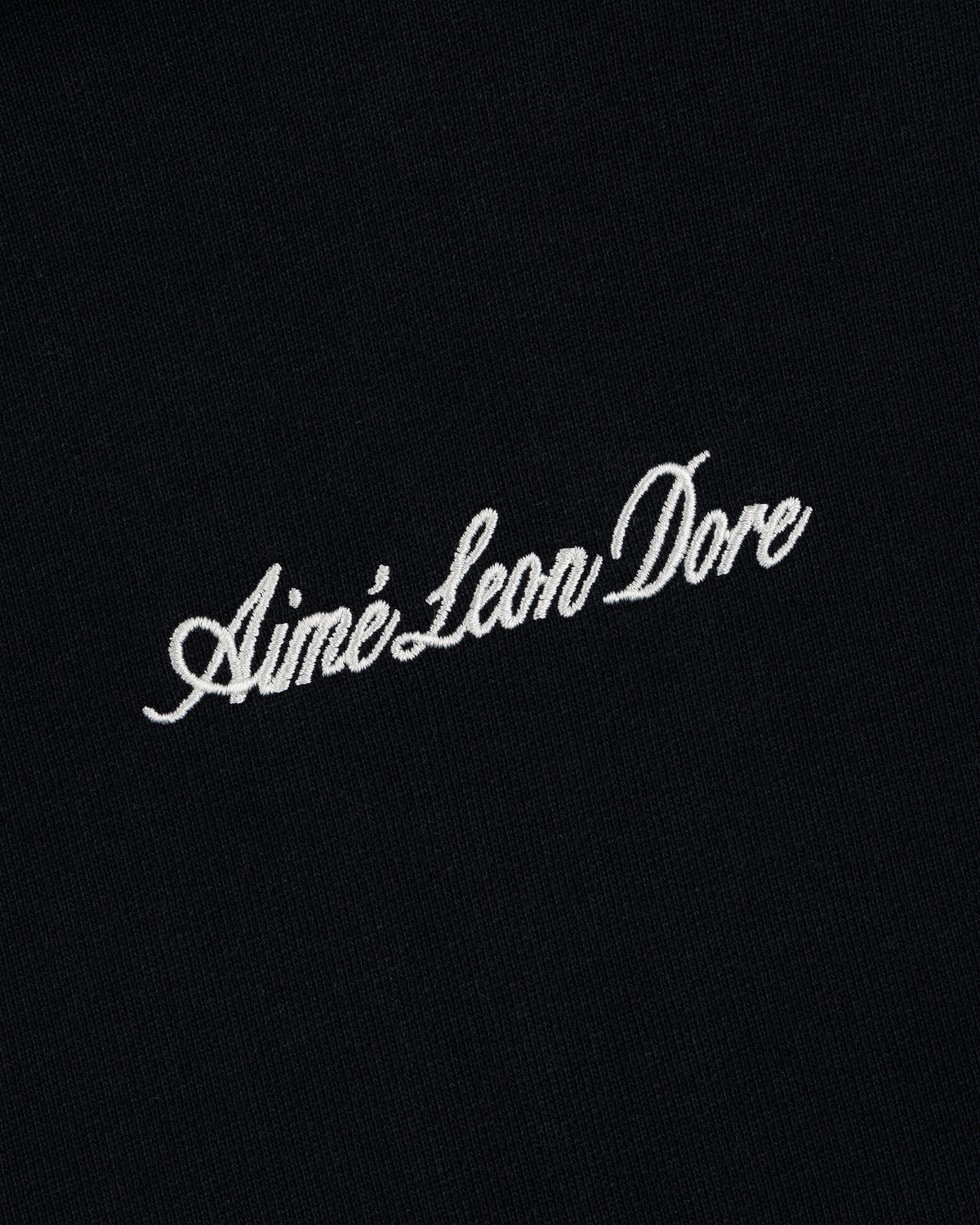 Black Embroidered Logo Hoodie with white "Aimé Leon Dore" cursive embroidery centered on the front.