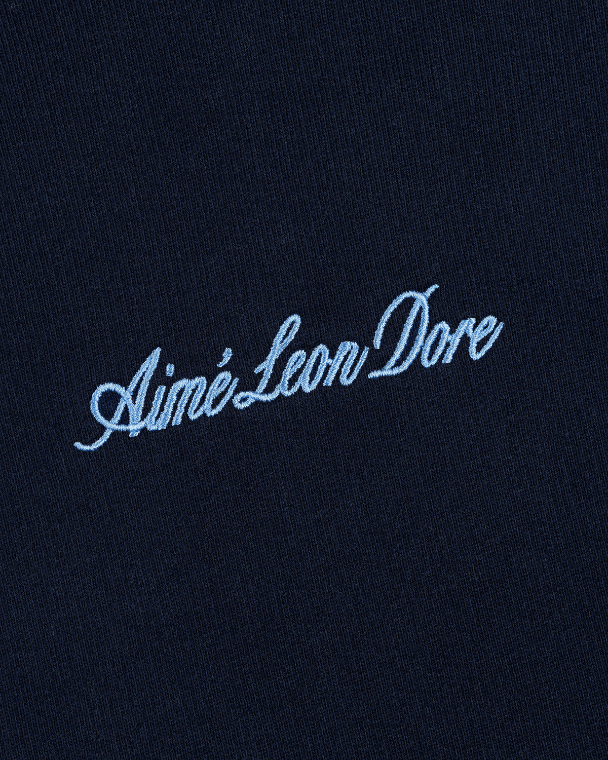 Navy blue Embroidered Logo Hoodie with Aimé Leon Dore in light blue cursive text.
