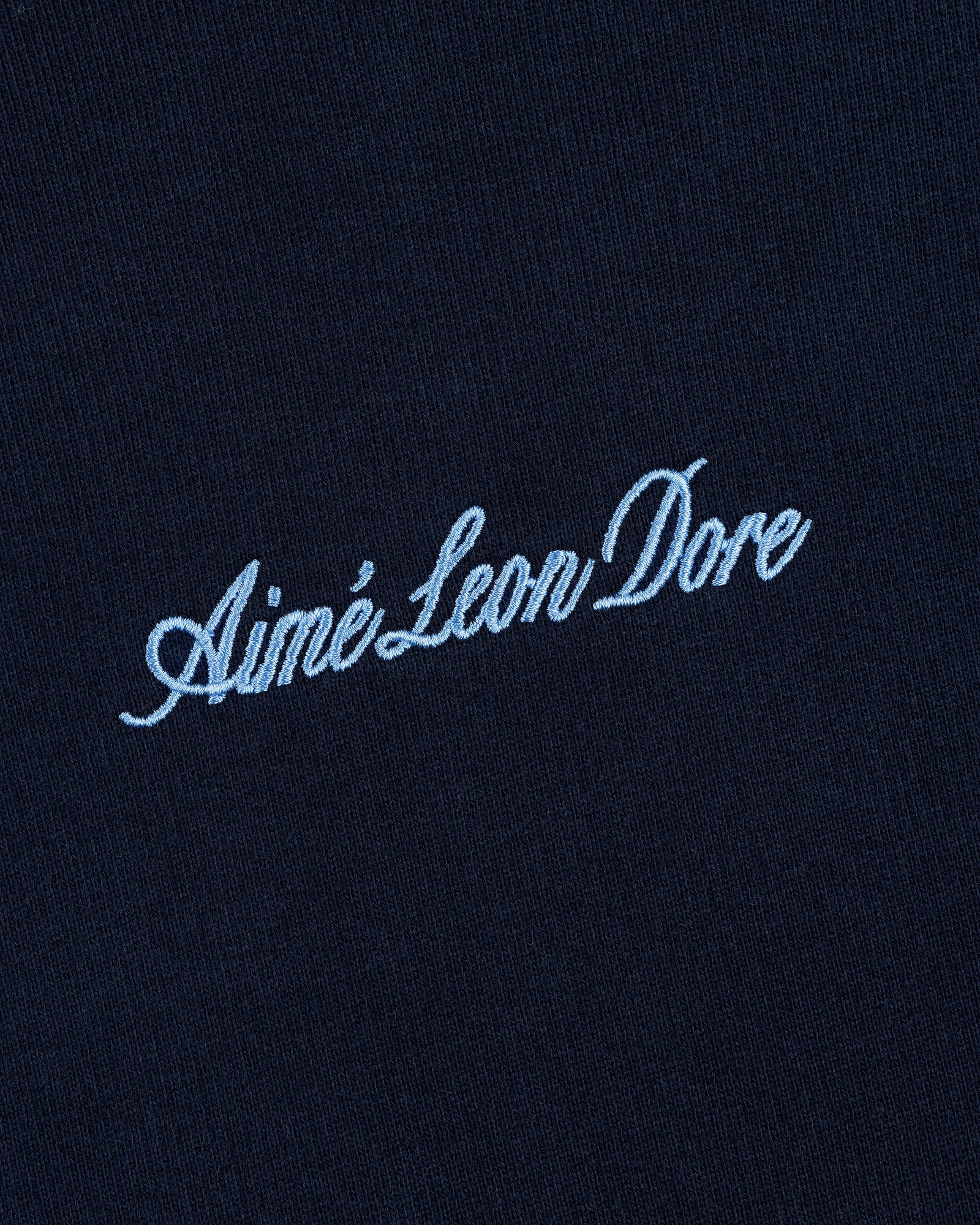 Navy blue Embroidered Logo Hoodie with Aimé Leon Dore in light blue cursive text.