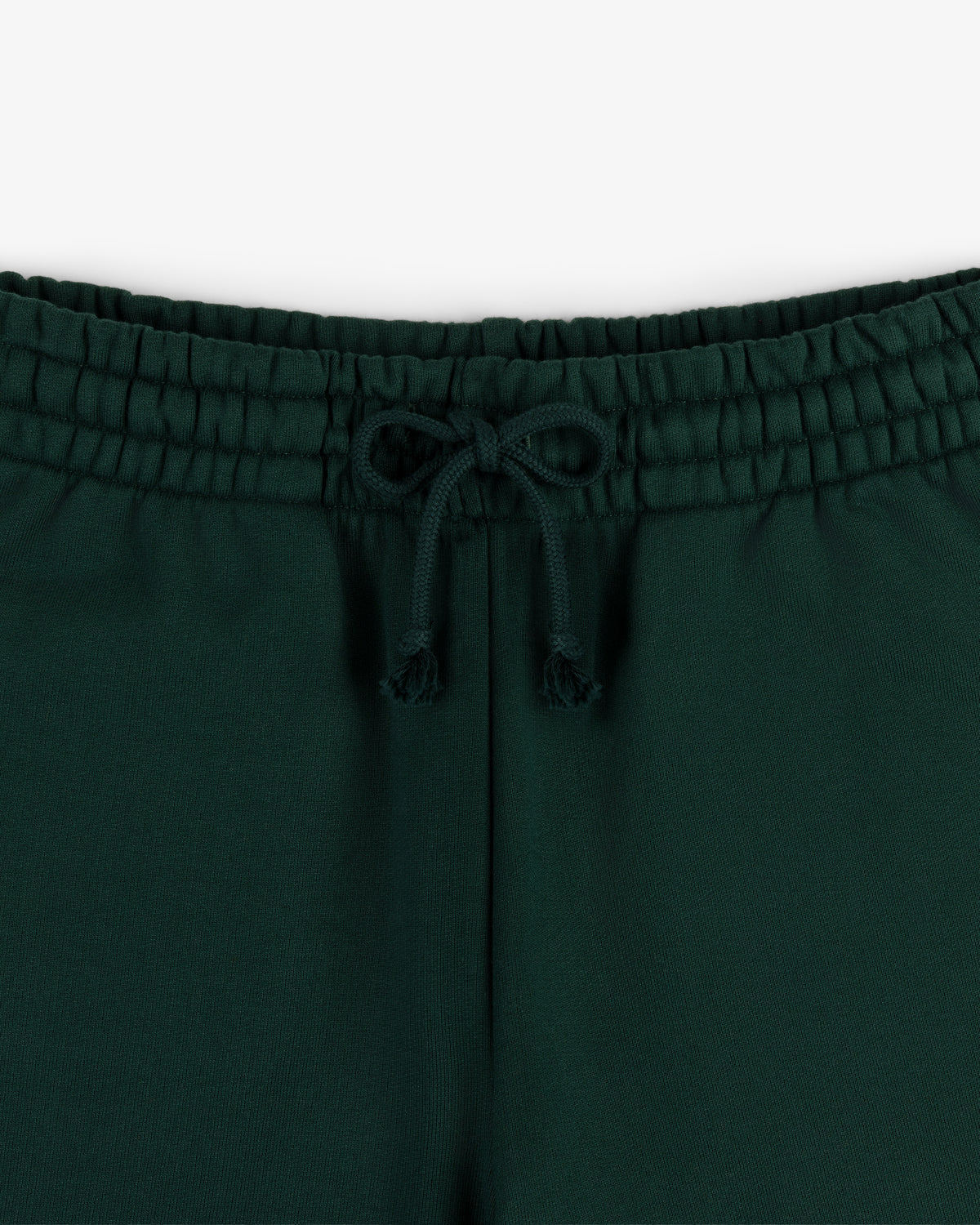 Close-up of Crest Sweatpants' dark green waistband with a drawstring bow, shown against a white background.