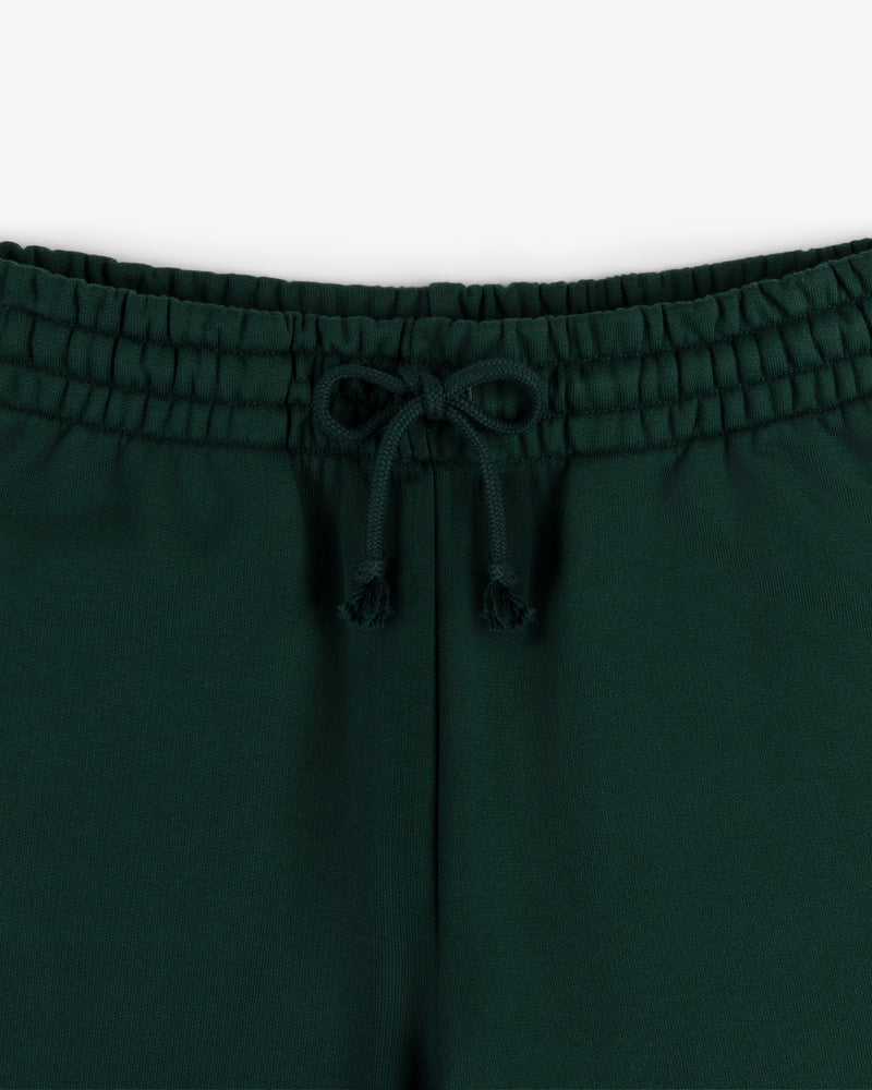 Close-up of Crest Sweatpants' dark green waistband with a drawstring bow, shown against a white background.