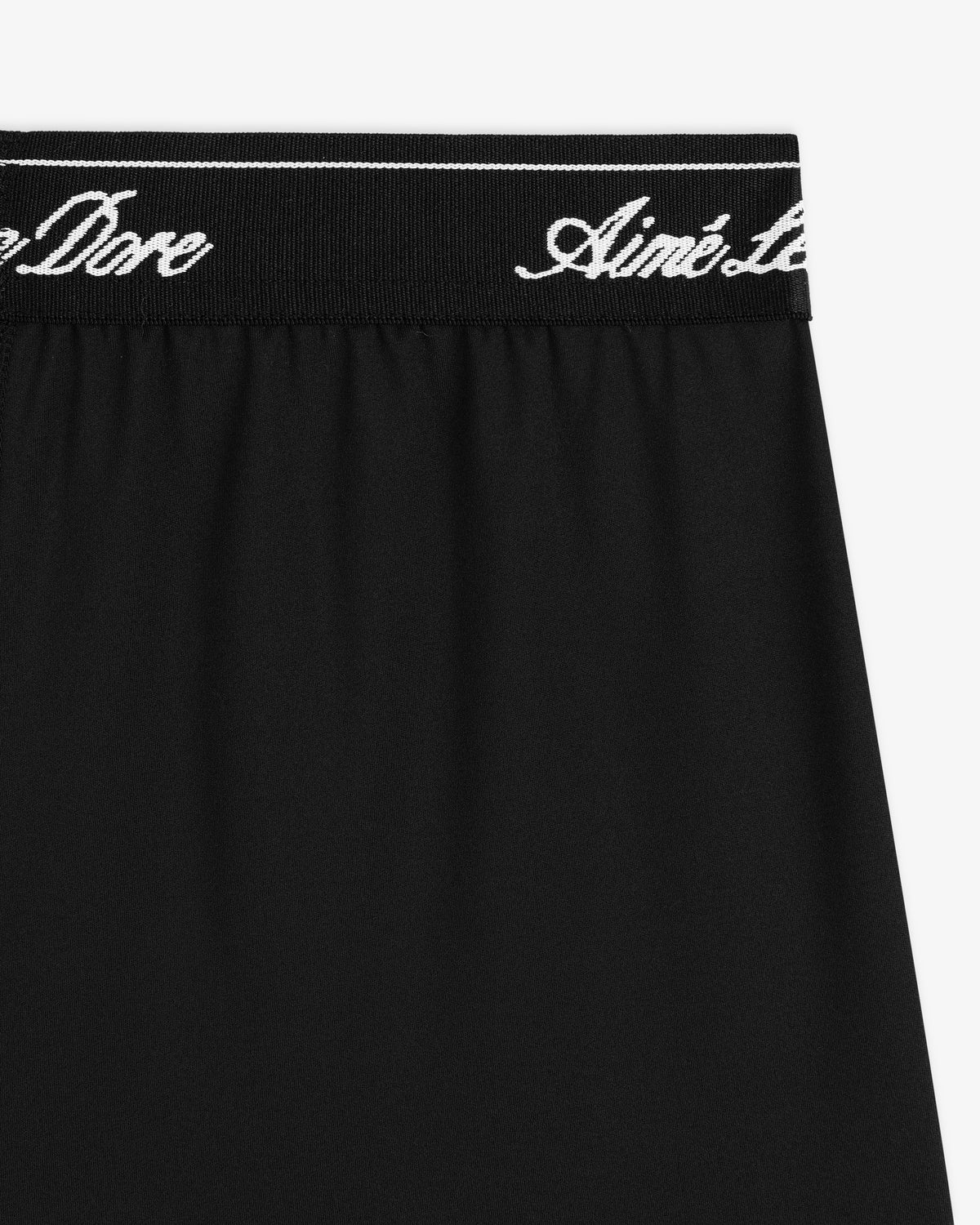 Close-up of Logo Biker Short: black fabric with a black waistband featuring white cursive Aimé Leon Dore text.