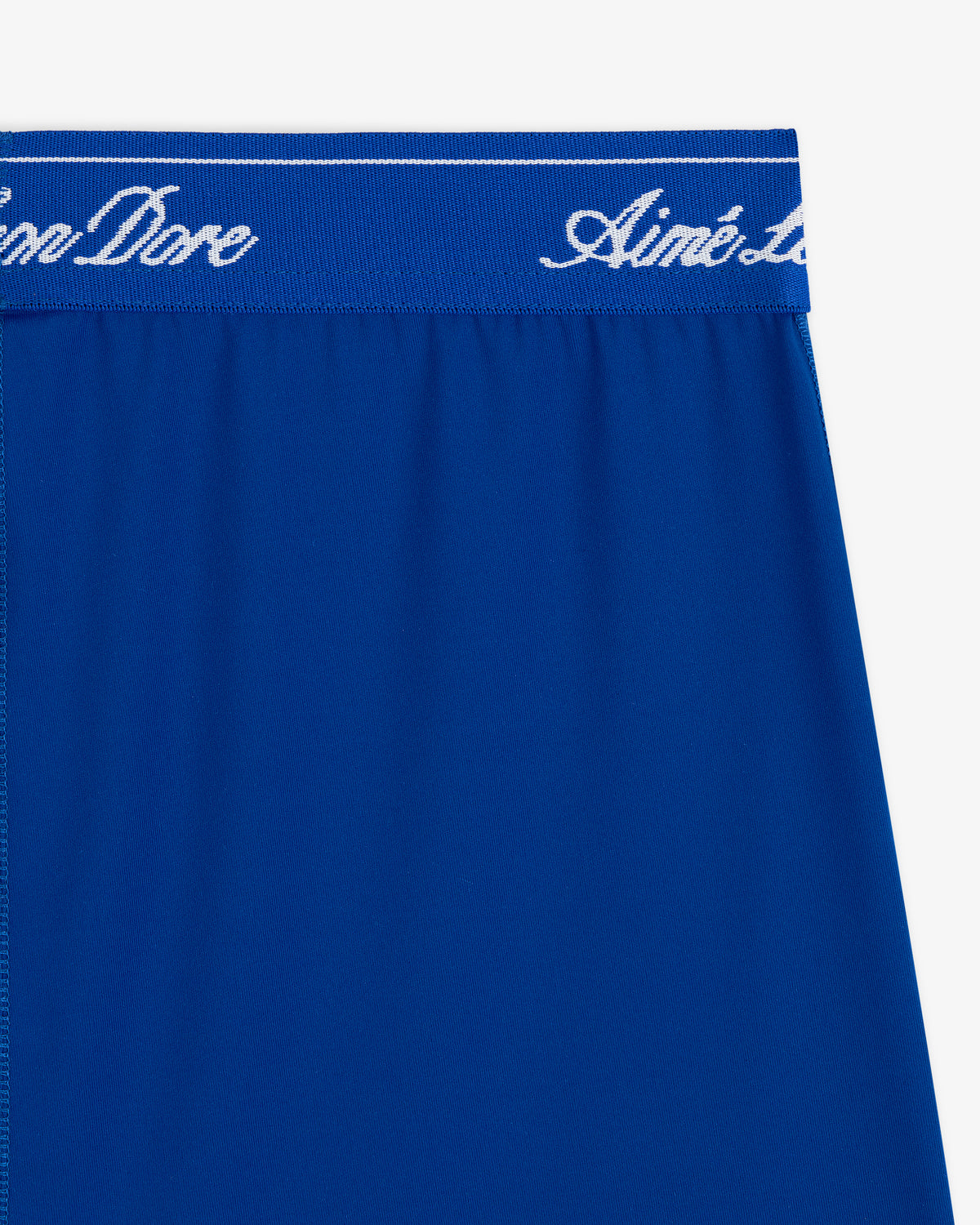 Close-up of Logo Biker Short in blue, featuring a waistband with white cursive Aimé Leon Dore text.