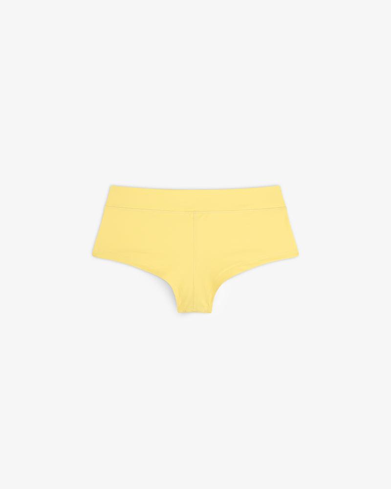 Crest Swim Short in yellow for women displayed on a white background.