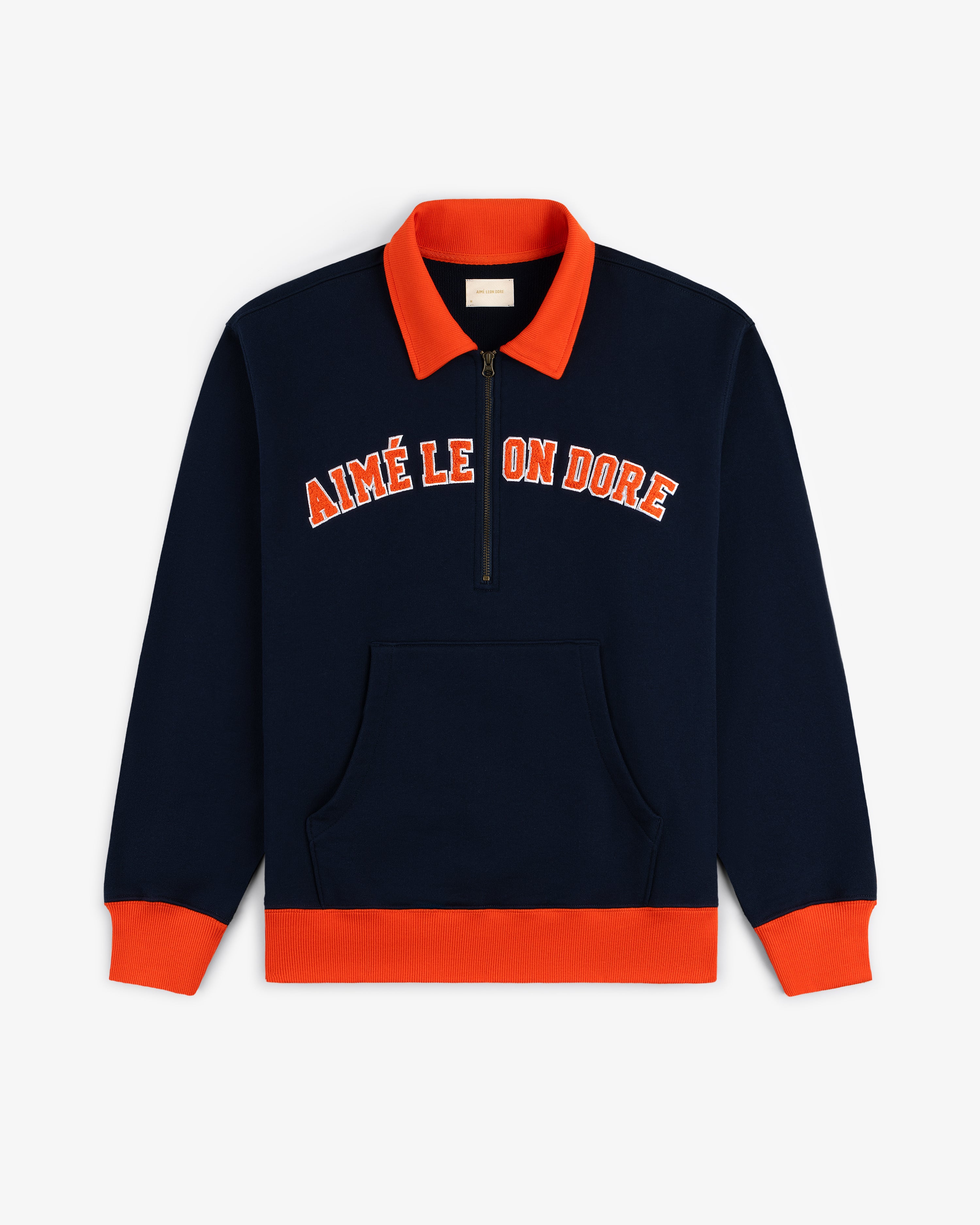 Navy Collegiate Quarter Zip Pullover with orange cuffs, collar, and AIMÉ LEON DORE text on the chest.
