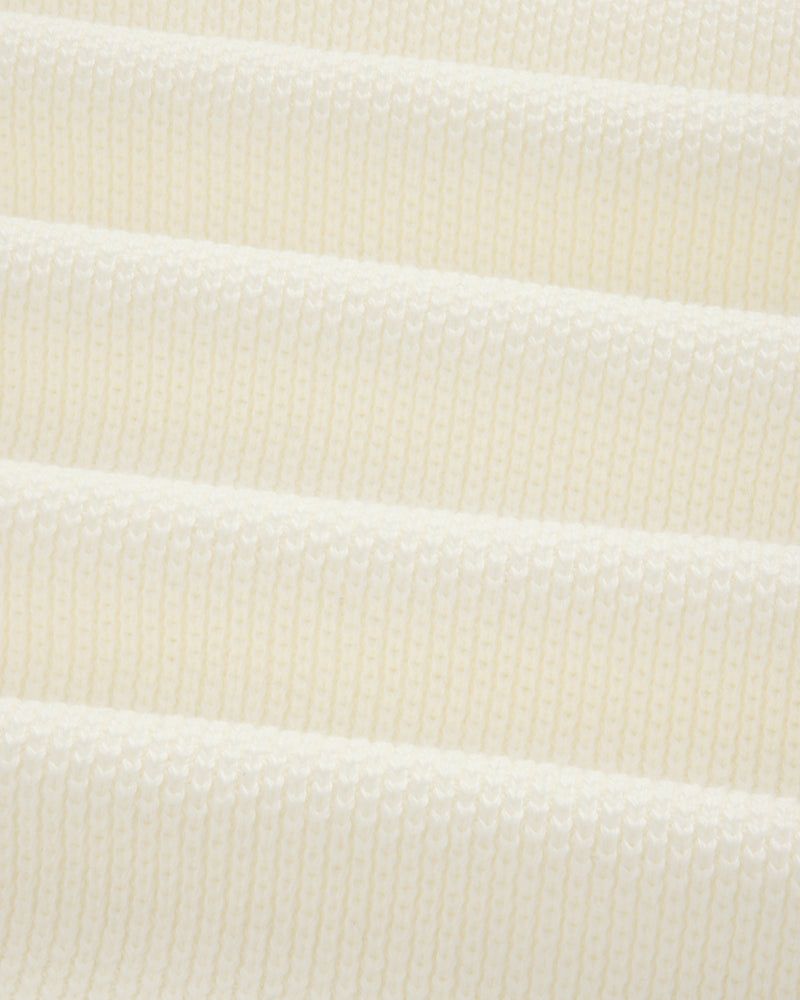Close-up of soft, ribbed off-white ALD Golf Piqué Full Zip Sweater knit fabric in gentle horizontal folds.
