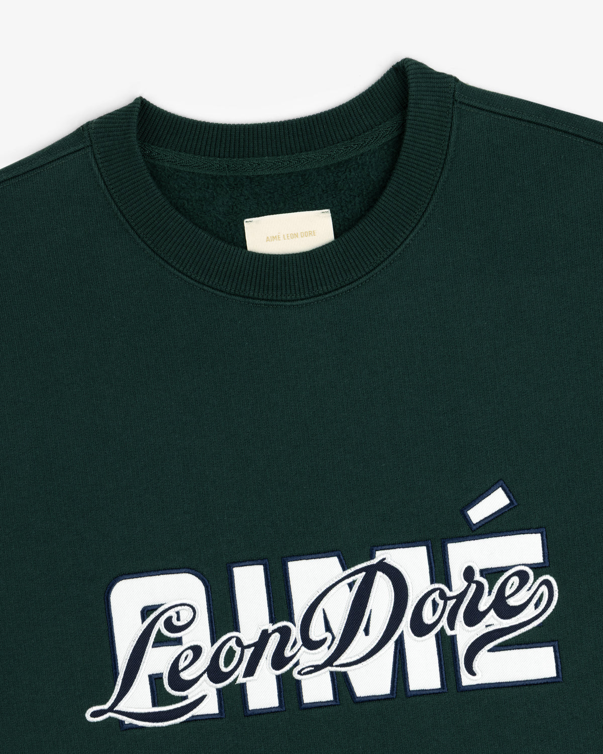 Overlay Logo Crewneck Sweatshirt in dark green with AIMÉ Leon Dore embroidered in white and navy on the chest.