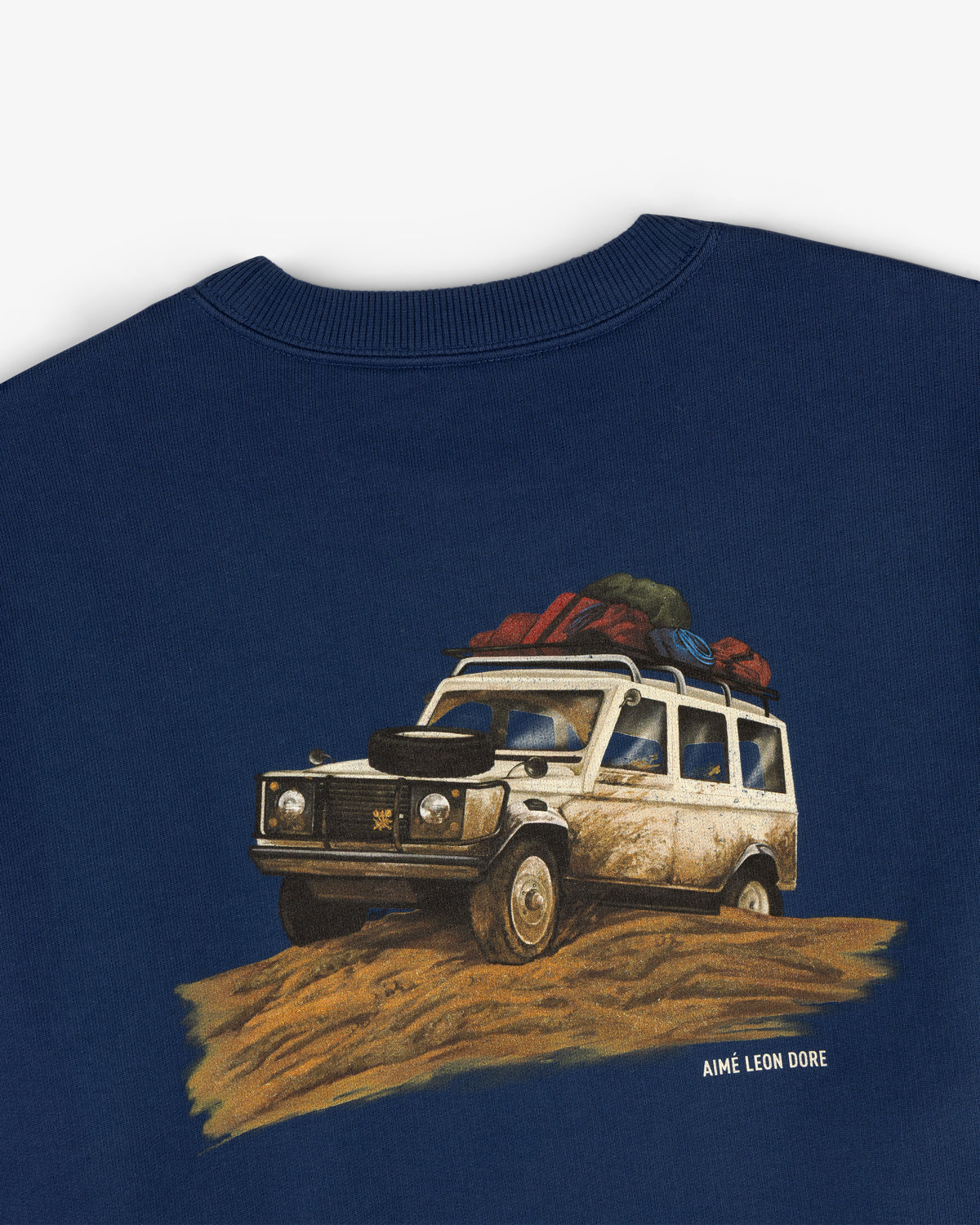 Safari Crewneck Sweatshirt featuring a loaded off-road vehicle illustration and AIMÉ LEON DORE text below the image.