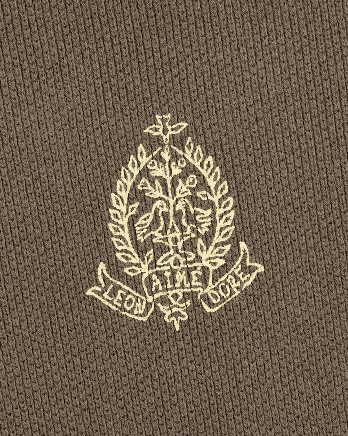Embroidered crest with leaves and "LEON AIME COPE" on brown Saint George Piqué Crewneck Sweatshirt.